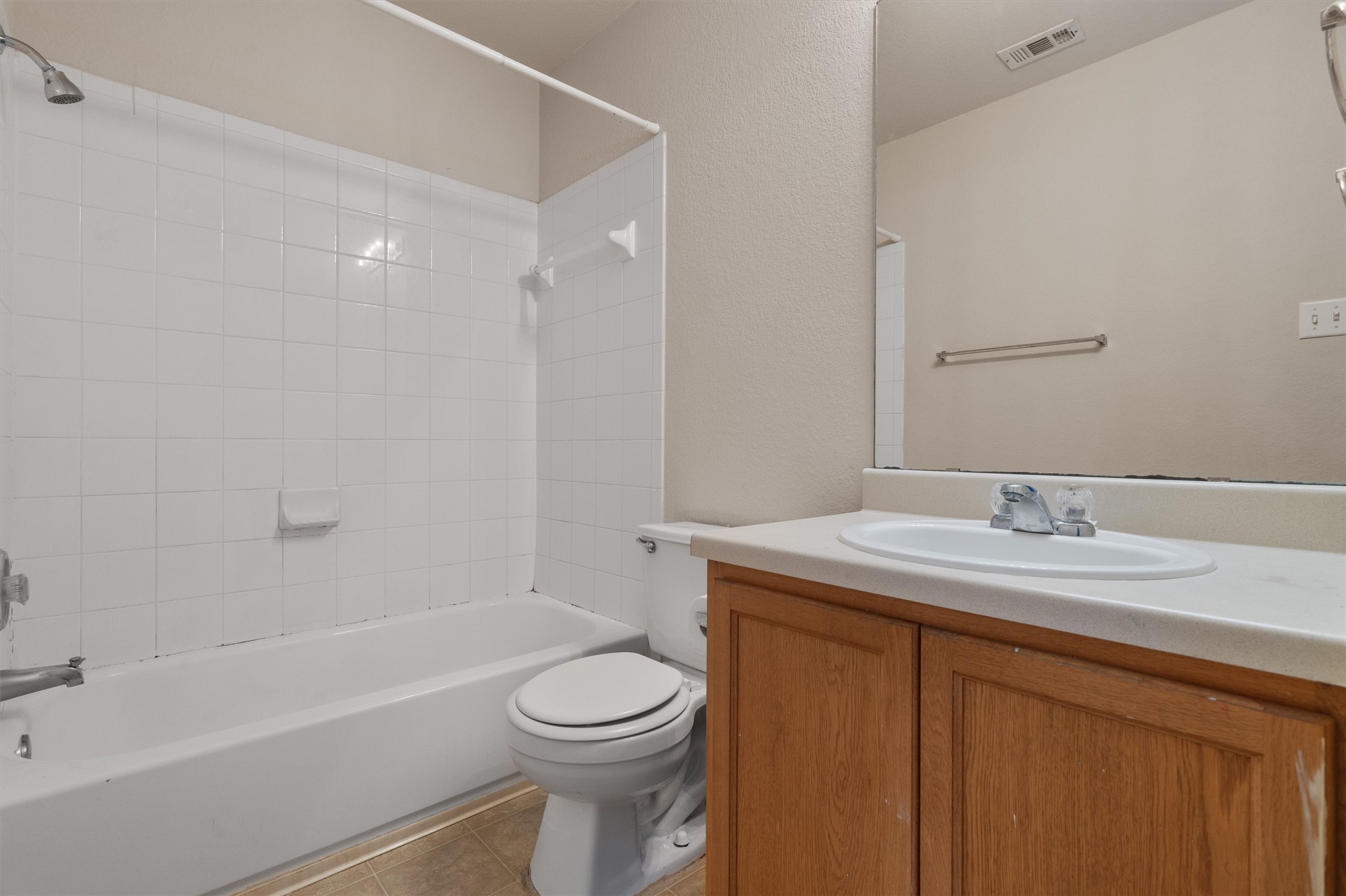 13720 Harris Ridge Boulevard, Unit A Pflugerville, TX 78660 - Photo 22 of 27 Bathroom with vanity, shower / bathtub combination, light tile patterned floors, and a textured wall