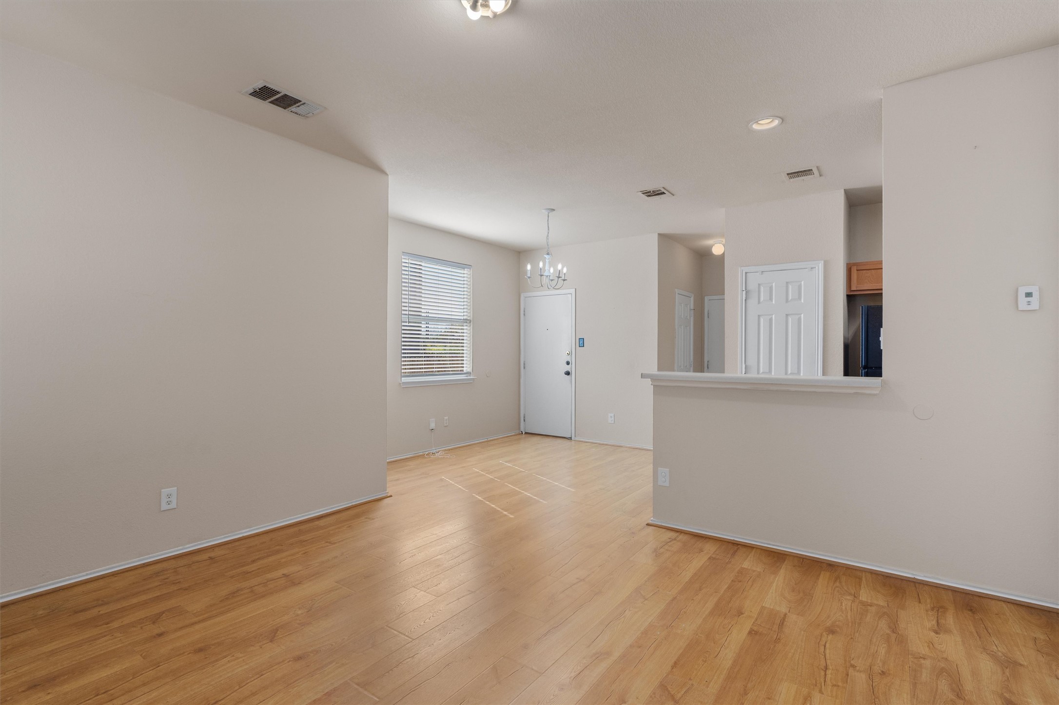 13720 Harris Ridge Boulevard, Unit A Pflugerville, TX 78660 - Photo 4 of 27 Unfurnished room with suspended lighting and light wood finished floors