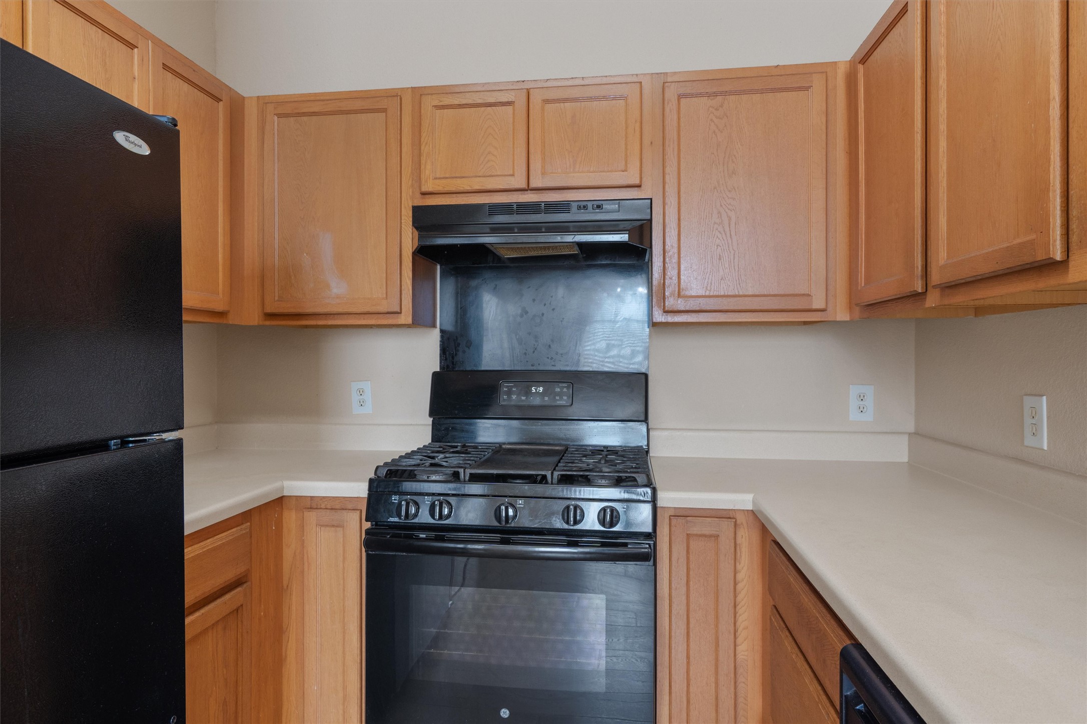 13720 Harris Ridge Boulevard, Unit A Pflugerville, TX 78660 - Photo 10 of 27 Kitchen featuring black appliances, light countertops, and range hood