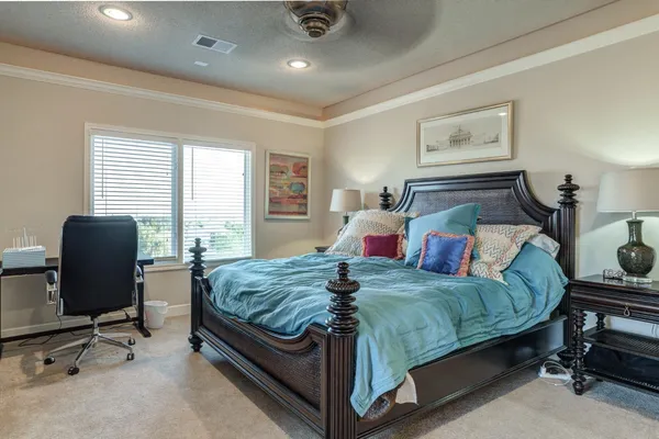 a bedroom with a bed and large windows