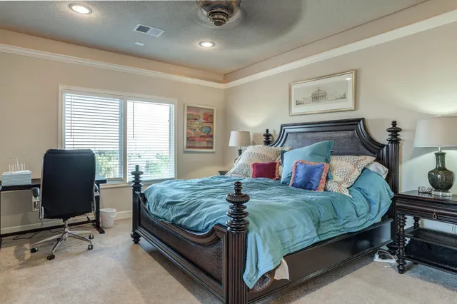 a bedroom with a bed and large windows