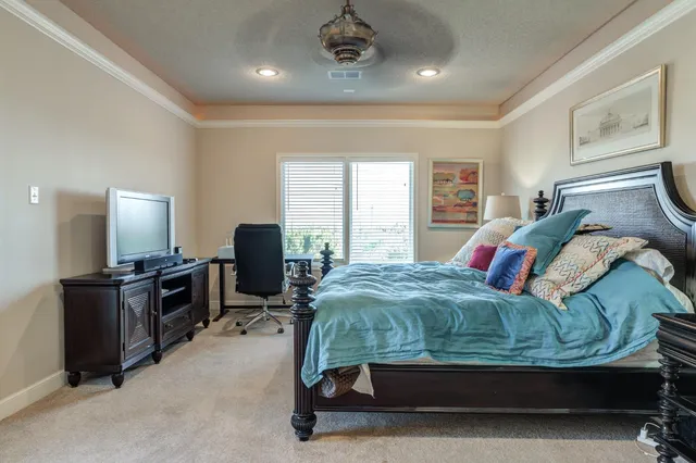 a bedroom with a bed gym equipment and large windows