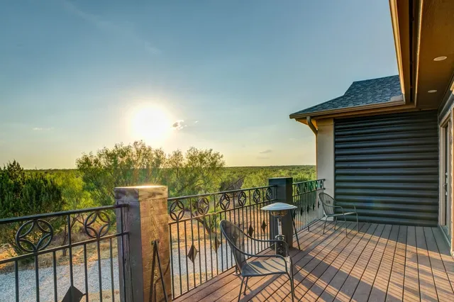 a view of a balcony with wooden floor and outdoor seating