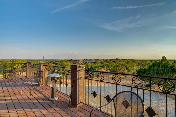a view of a balcony with wooden floor and iron stairs