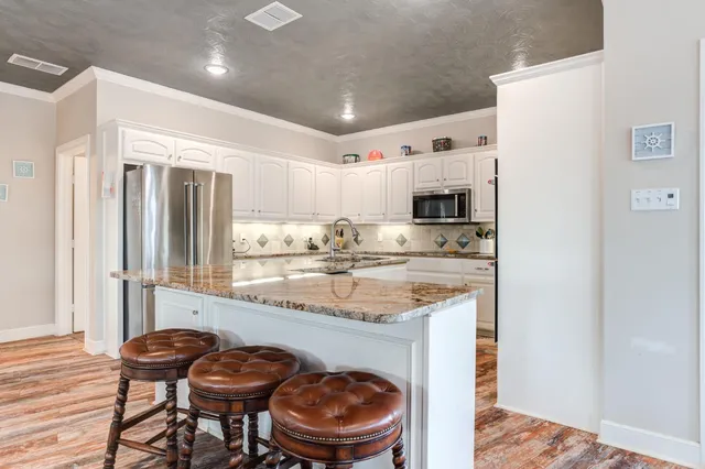 a kitchen with granite countertop a sink and a refrigerator