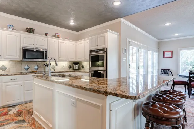 a kitchen with stainless steel appliances kitchen island granite countertop a stove sink and microwave