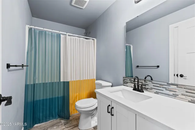 a bathroom with a sink a toilet and shower