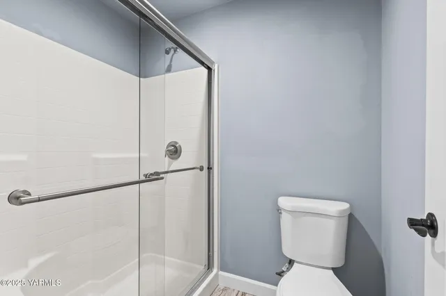 a bathroom with a toilet and a shower