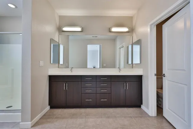 a spacious bathroom with a granite countertop sink a mirror and a vanity