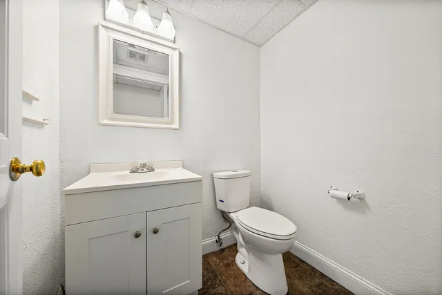 a bathroom with a toilet sink and mirror