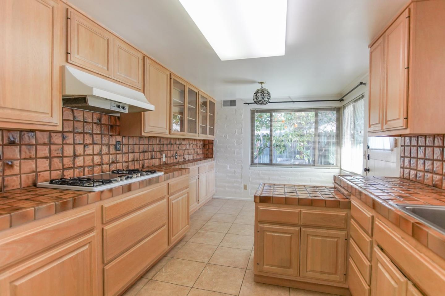 1521 Cienega Road Hollister, CA 95023 - Photo 35 of 56 a kitchen with kitchen island granite countertop white cabinets and white appliances