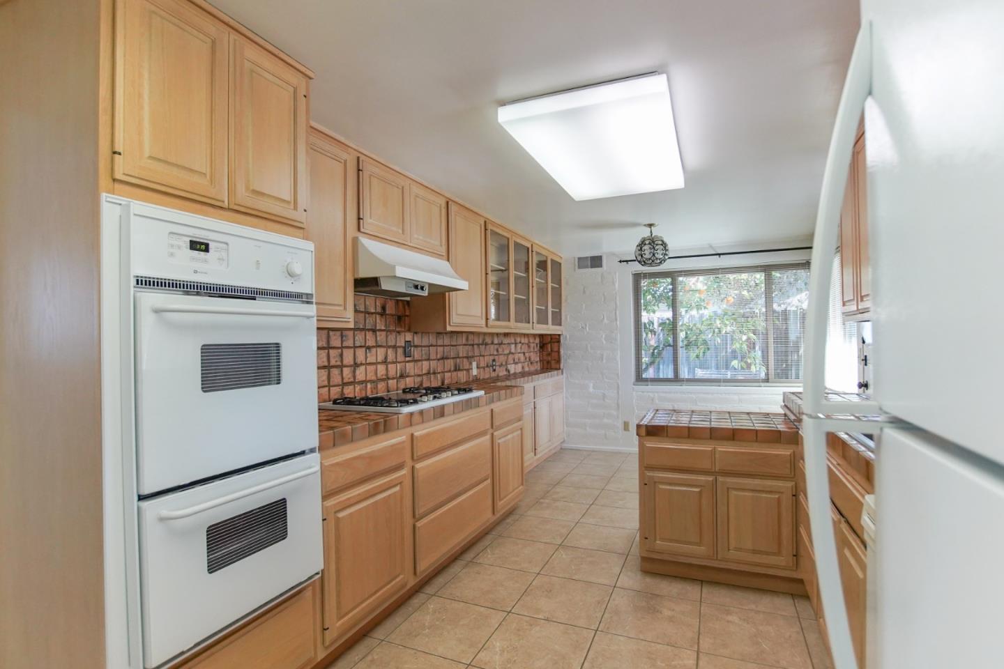 1521 Cienega Road Hollister, CA 95023 - Photo 37 of 56 a kitchen with stainless steel appliances granite countertop white cabinets and window