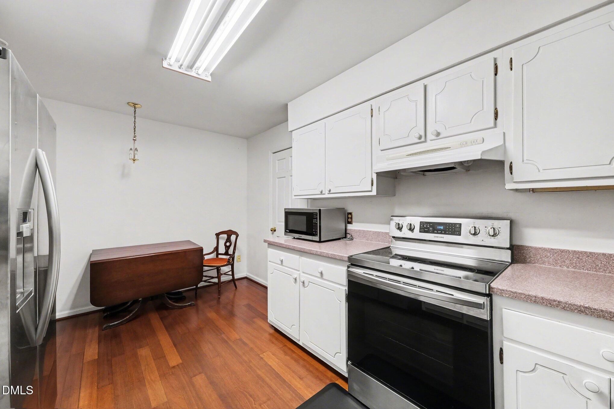 1911 Front Street, Unit 3B Durham, NC 27705 - Photo 10 of 33 a kitchen with cabinets appliances and wooden floor