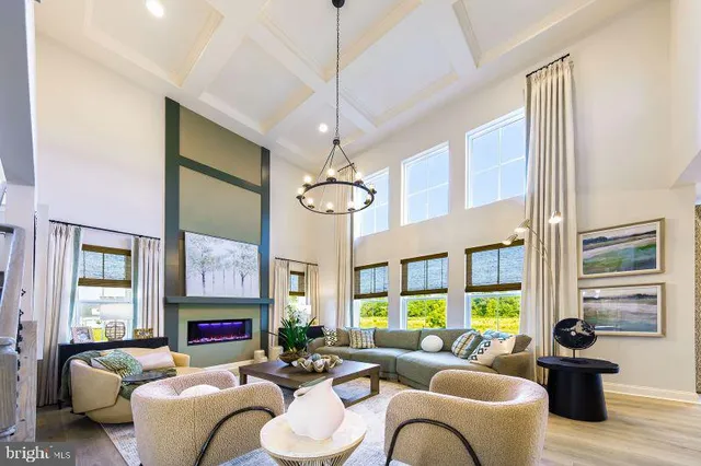 a living room with furniture a chandelier and a fireplace