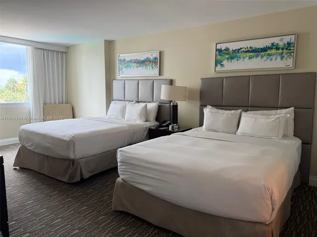 a bedroom with two beds and painting on the wall