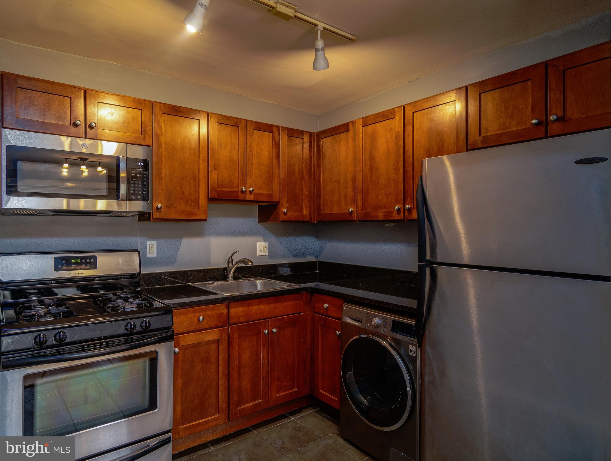a kitchen with stainless steel appliances granite countertop a washer and dryer