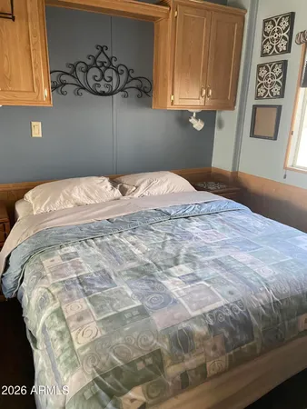 a bedroom with a bed and painting on the wall