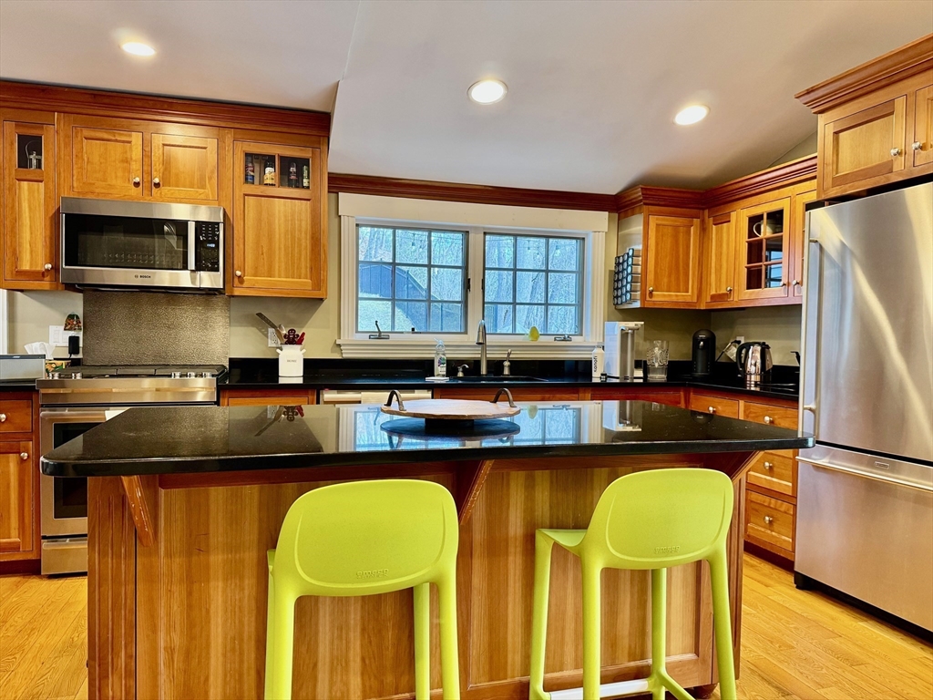 601 Lexington Road Concord, MA 01742 - Photo 3 of 16 a kitchen with a refrigerator a stove a sink and a cabinets
