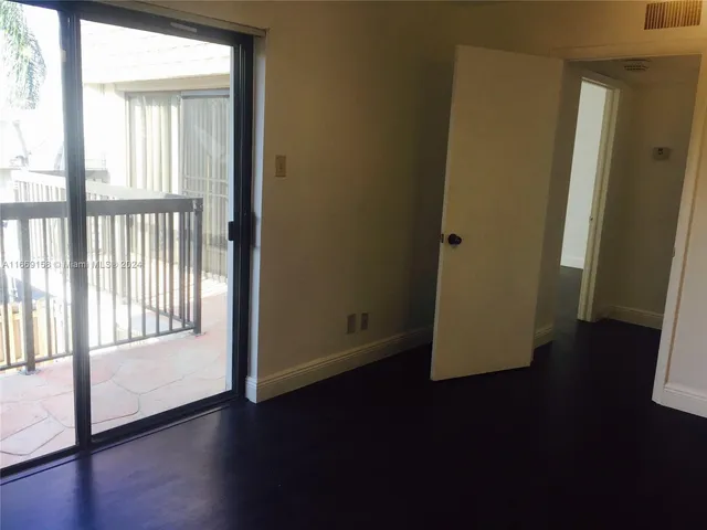 a view of a hallway with wooden floor and a window