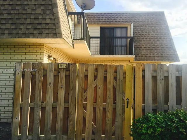 a view of a house with wooden fence