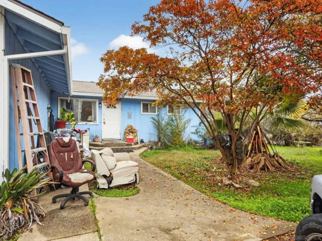 a view of a house with backyard and sitting area