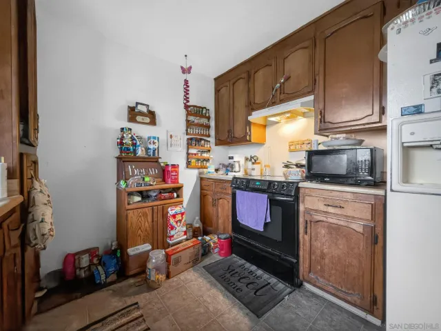 a kitchen with kitchen island granite countertop a sink stove and cabinets