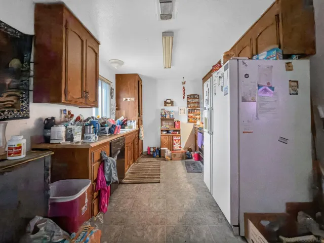 a kitchen with stainless steel appliances kitchen island granite countertop a refrigerator and a sink
