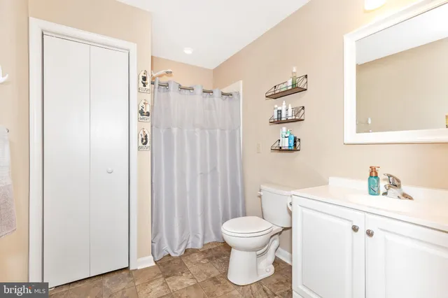 a bedroom with a bed a large window and walk in closet