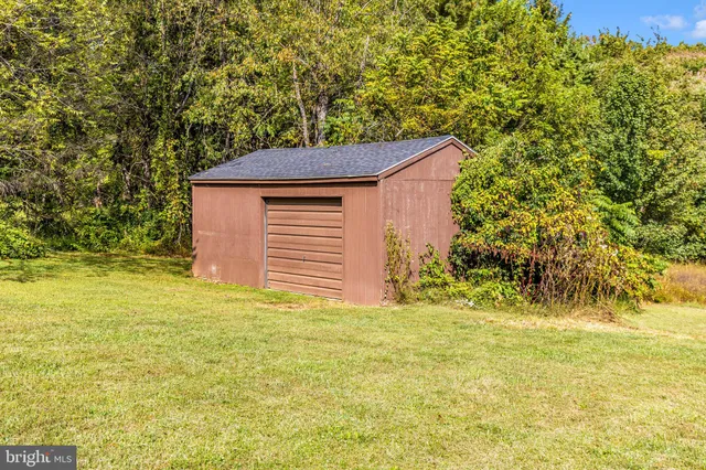 a view of a house with a yard and a tree