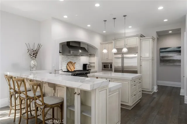 a kitchen that has a lot of cabinets in it and wooden floors