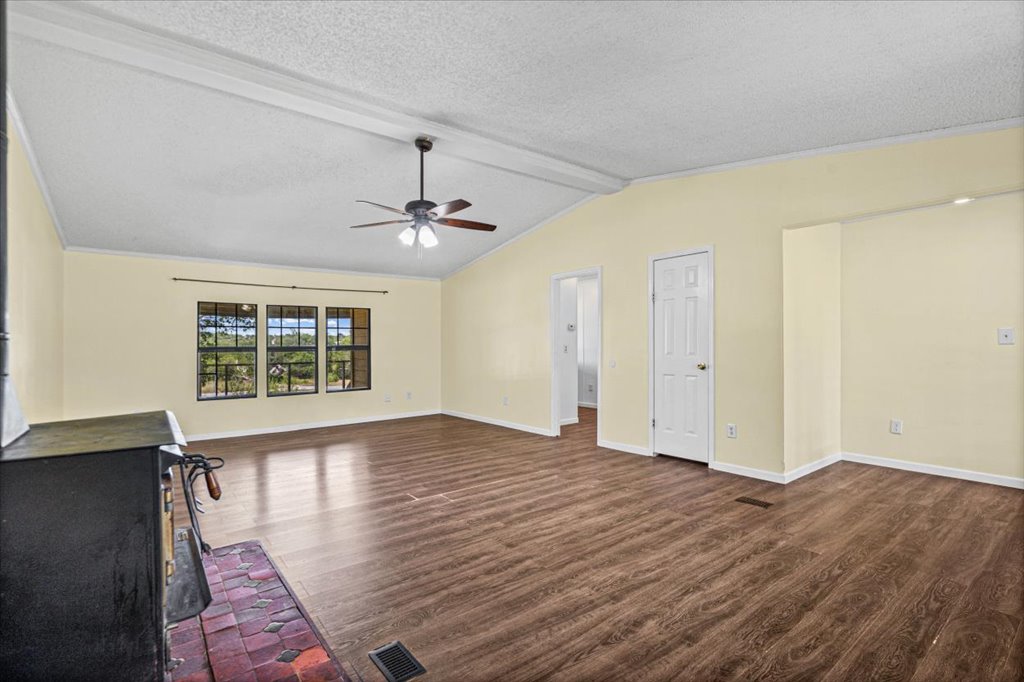 13501 Nutty Brown Road, Unit B Austin, TX 78737 - Photo 6 of 29 A spacious common area with vaulted ceilings and rich wood-tone flooring offers abundant natural light.