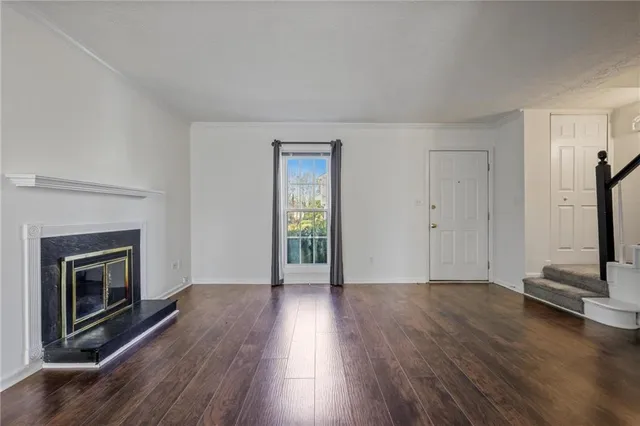 a view of a livingroom with wooden floor and a fireplace
