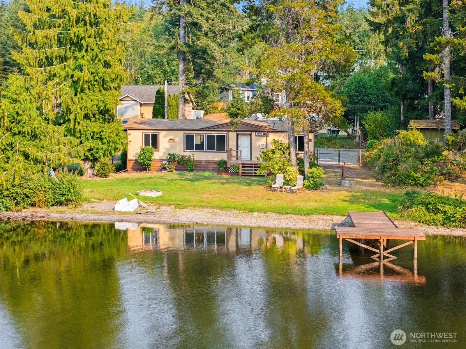 1171 E Trail Belfair, WA 98528 - Photo 2 of 29 a view of a swimming pool with lawn chairs and plants