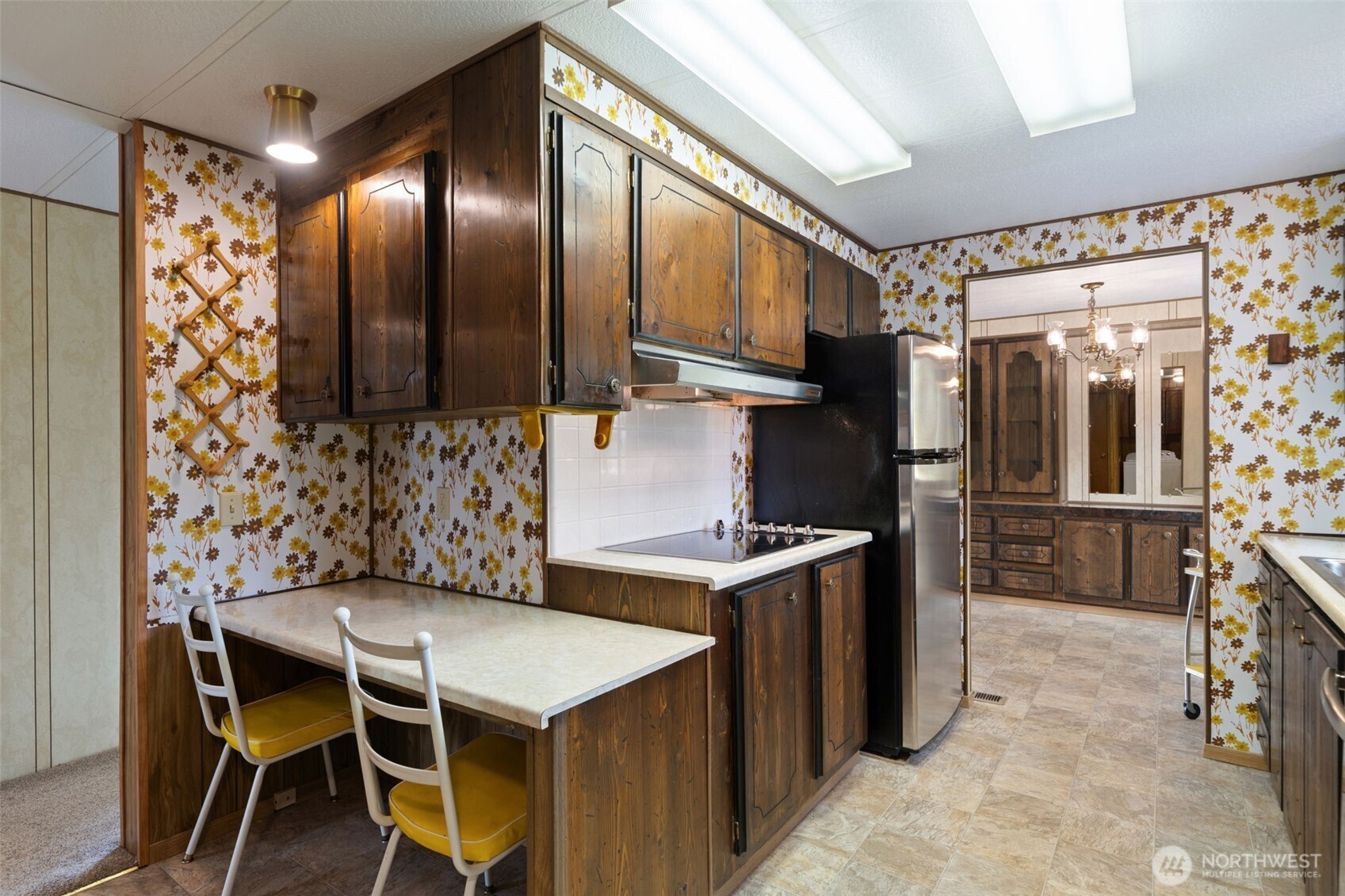 1171 E Trail Belfair, WA 98528 - Photo 7 of 29 a kitchen with a table chairs refrigerator and cabinets