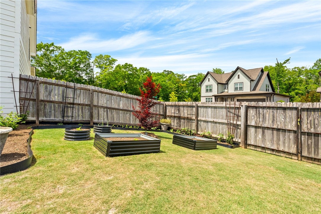 2324 Rutland Road Auburn, AL 36832 - Photo 22 of 22 This spacious yard features raised garden beds and a sturdy fence, perfect for outdoor living.