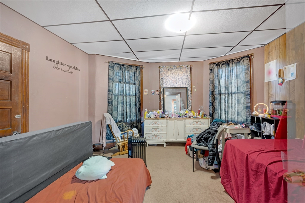 14 Mendon Street Worcester, MA 01604 - Photo 12 of 17 a bedroom with furniture and a chandelier
