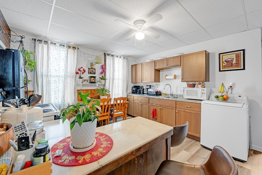 14 Mendon Street Worcester, MA 01604 - Photo 7 of 17 a kitchen with stainless steel appliances granite countertop a refrigerator a sink dishwasher and white countertops with wooden floor