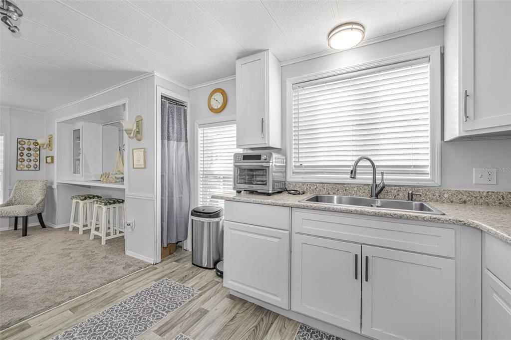 4454 Tucker Square New Port Richey, FL 34652 - Photo 19 of 64 a kitchen with stainless steel appliances granite countertop a sink and a window