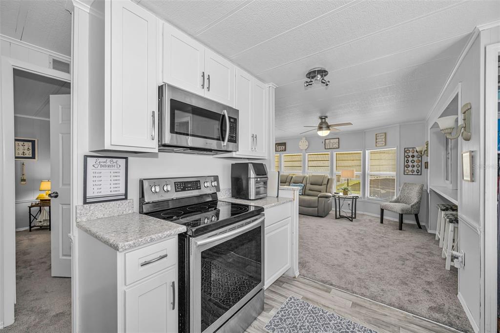 4454 Tucker Square New Port Richey, FL 34652 - Photo 20 of 64 a kitchen with stainless steel appliances a stove microwave and refrigerator