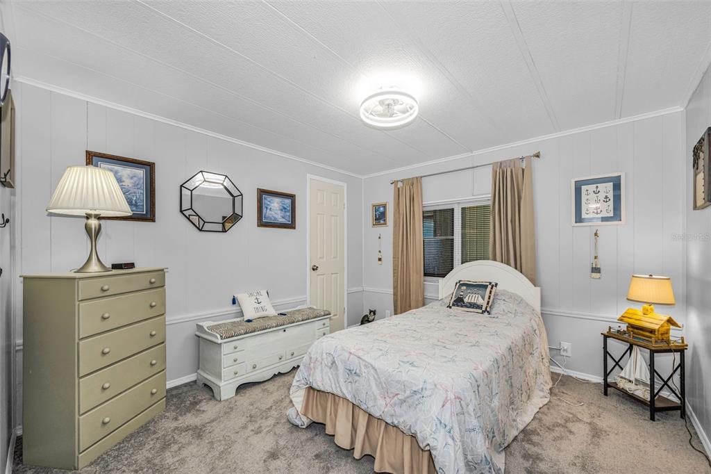 4454 Tucker Square New Port Richey, FL 34652 - Photo 27 of 64 a bedroom with a bed and a chandelier