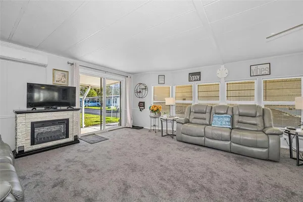 a living room with furniture a ceiling fan and a window
