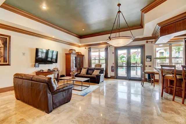 a living room with furniture a flat screen tv and floor to ceiling windows