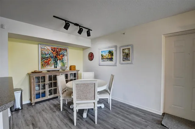 a view of a dining room with furniture a rug and wooden floor