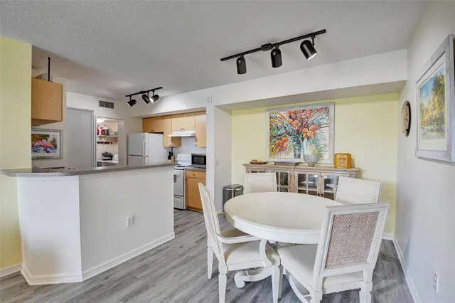 a kitchen with stainless steel appliances a dining table and chairs