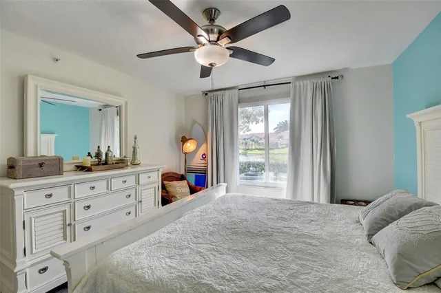 a bedroom with a bed dresser and a large window