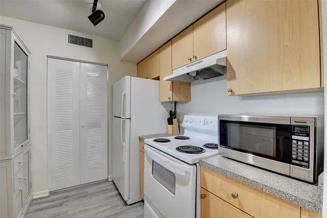 a kitchen with stainless steel appliances a stove a refrigerator and cabinets