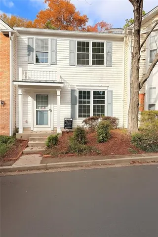 a front view of a house with a garden and plants