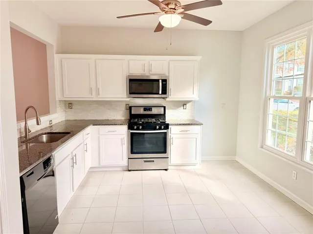 a kitchen with stainless steel appliances a stove sink microwave and cabinets