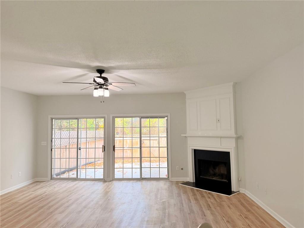 10900 Wittenridge Drive, Unit C7 Alpharetta, GA 30022 - Photo 9 of 31 wooden floor fireplace and windows in an empty room