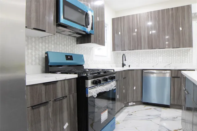 a kitchen with stainless steel appliances granite countertop a sink stove and refrigerator